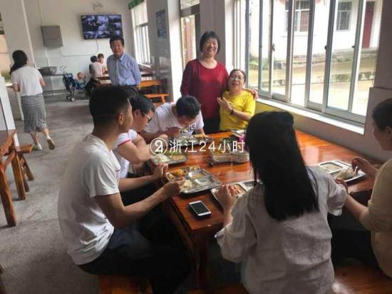 (图:陈小美开心地看着老师们津津有味吃她做的小菜)