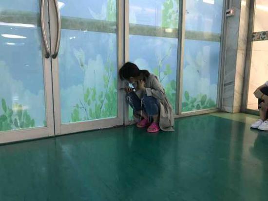 张婷在ICU病房门缝里看,期待得到儿子的消息