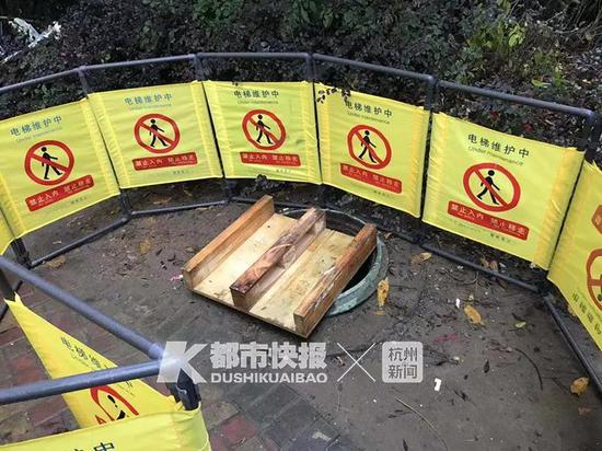 昨天,出事的窨井被围起,有人在旁边放了鲜花。见习记者 朱家豪摄