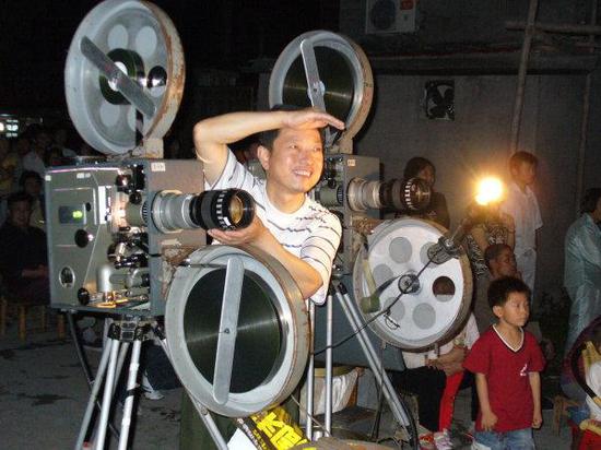 10多年前,杨志平操作35毫米电影放映机为大家服务。
