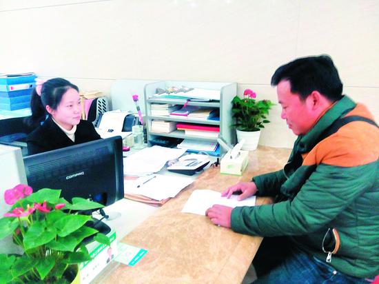 一名群众正在领取“春风行动”外来务工人员救助金 (资料图)