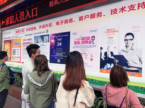南方人才市场门口,几个女孩在看招聘信息。|摄影:小达