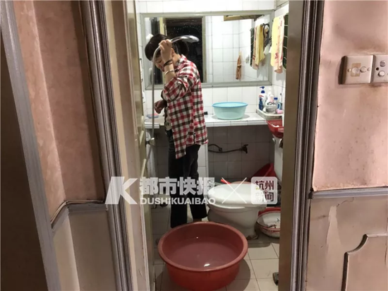 6楼杨女士演示着她们家洗澡的样子