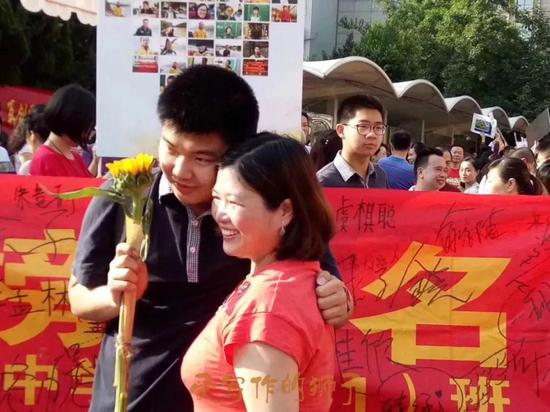 育才中学校长郜晏中,带着老师们站在门口。校长说:谢谢大家,祝孩子们成功!