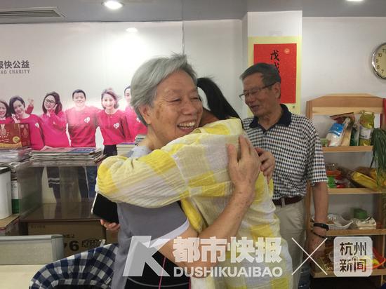 阳光学子包沁灵(中)和杨爷爷一家见面 资料图