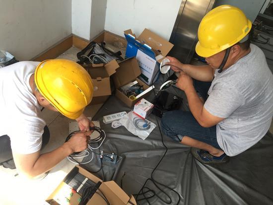 图为安装智慧电梯工作人员正在作业。越城区市场监管局供图