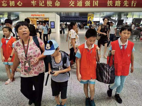 五年级小学生朱紫琪和曹宇歌帮旅客搬运行李