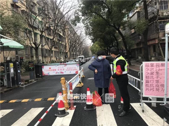 大关西三苑门口,保安正在为居民测体温。记者 张娜 摄