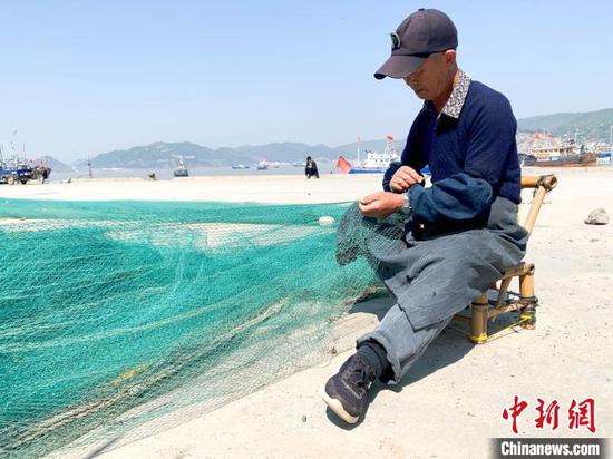 玉环市坎门中心渔港,渔民正在修补渔网。 吕琼雅 摄