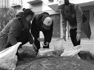 “垃圾分类监督员”对居民送下来的垃圾进行扫描检查并评分