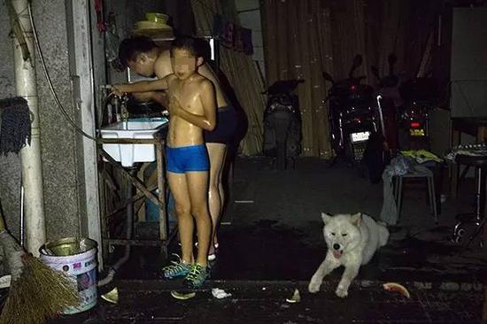 昨晚8点开始,银鼎商贸城部分住宅停电,一对父子在黑暗中淋浴。记者 葛亚琪 摄