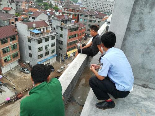 图为:民警对欲跳楼的男子进行劝导。傅村派出所供图