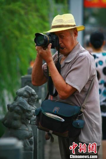 楼伯余老人在拍摄照片 湖州宣传部提供