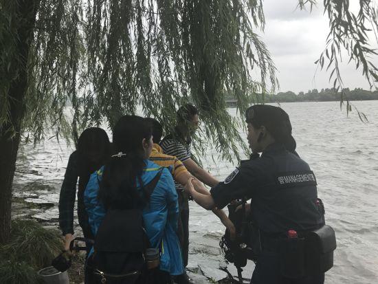 图为:西湖女子巡逻队将落水游客救助上岸。