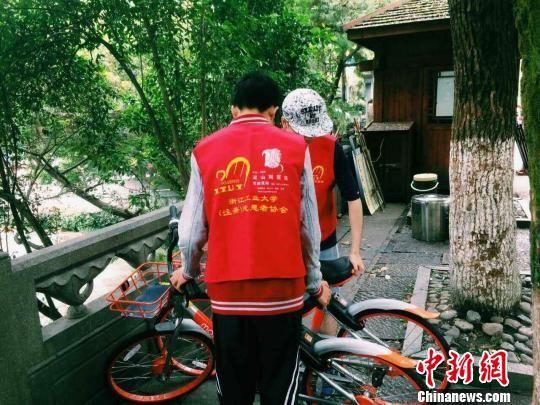 图为:志愿者整理共享单车。 王潇婧 摄