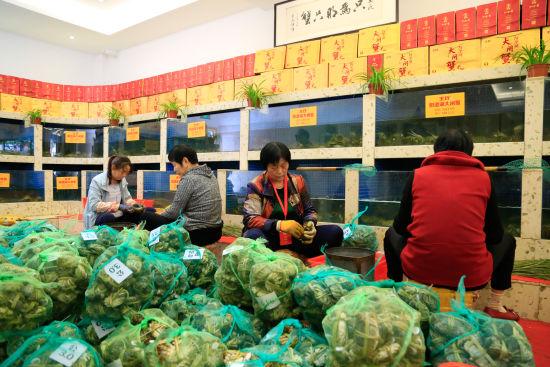 图为:捆蟹工面前堆满了捆好的一袋袋大闸蟹。 王远 摄
