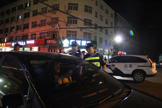 图为:民警对过往车辆进行询问。 松门派出所供图