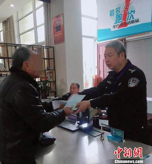 刘某接过自己的户口薄。 赵鎏杰 供图 摄