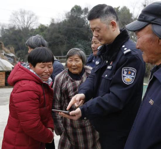 民警为杨通美展示贵州老家的视频资料。海盐警方供图