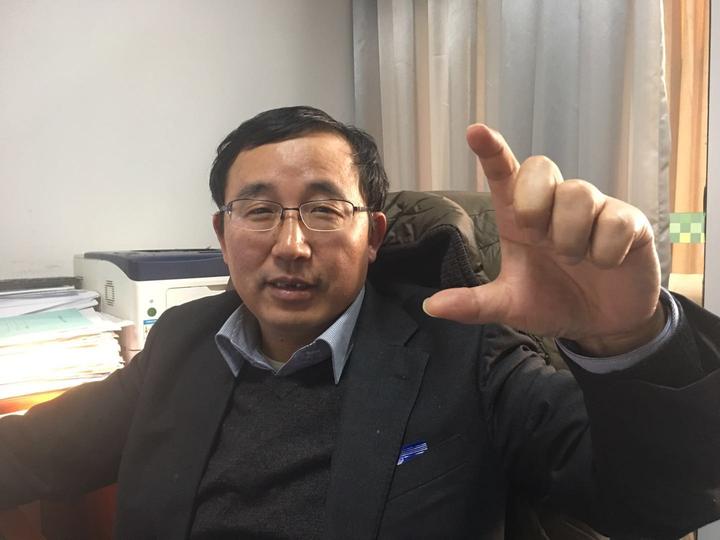 图:潘建治用手比划土猪肉肥膘