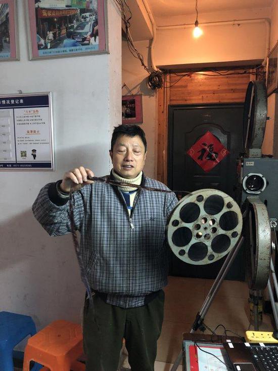 近日,杨志平在家中向记者演示如何组装老式放映机。