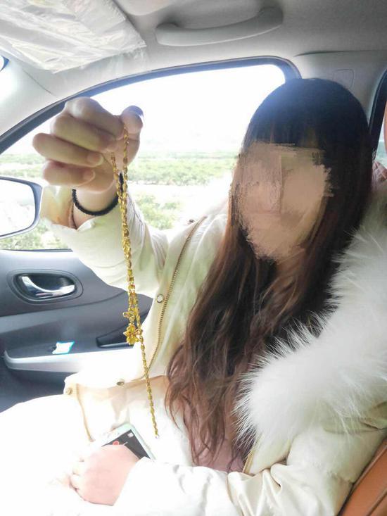 图为:女子取回失而复得的金项链。卓越摄