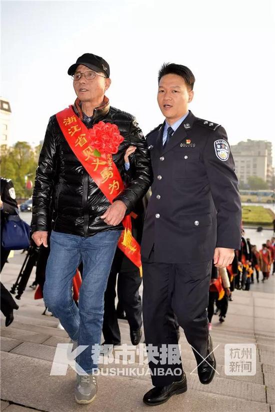(陈永德被民警扶着上台领奖)