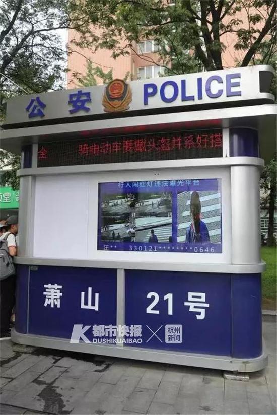 路口岗亭的大屏幕上正在曝光闯红灯的人