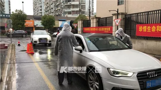 东新府门前,保安师傅正在对车里两位乘客测体温