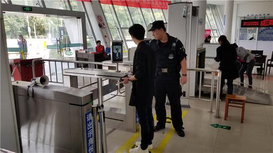图为定海金塘汽车客运站辅警队员指导乘客进入人证合验通道。 杨洁洁 摄