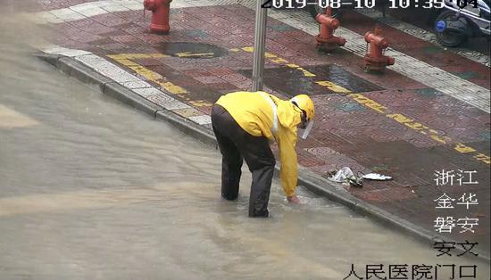图为:台风天外卖小哥沿路徒手清理积水。磐安公安提供