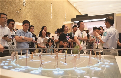 周新华(右)为市民讲解良渚文化知识