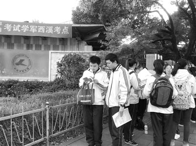 考前,考生在门口抓紧时间最后再看两道题。 首席记者 张娜 摄