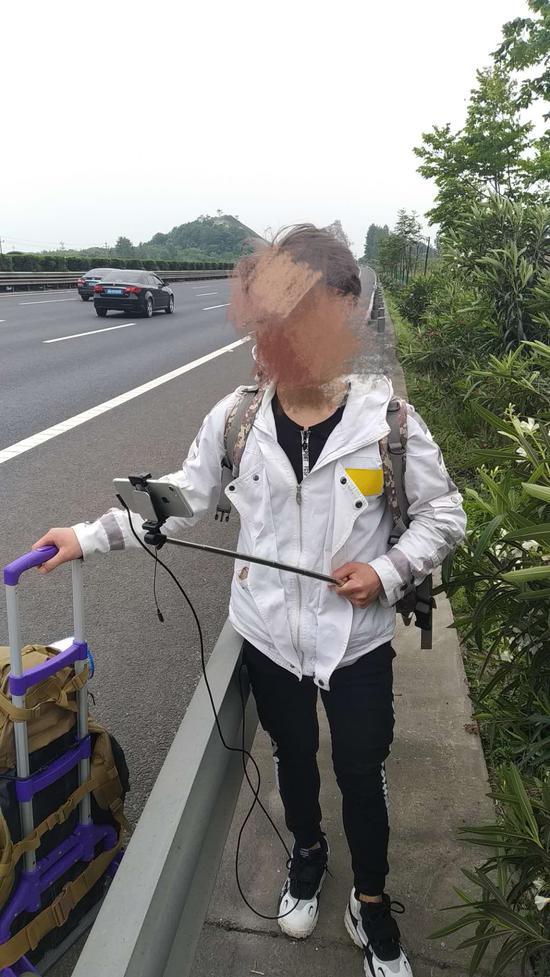 小伙身侧就是滚滚车流,着实让高速交警捏了把汗。金华高速交警提供