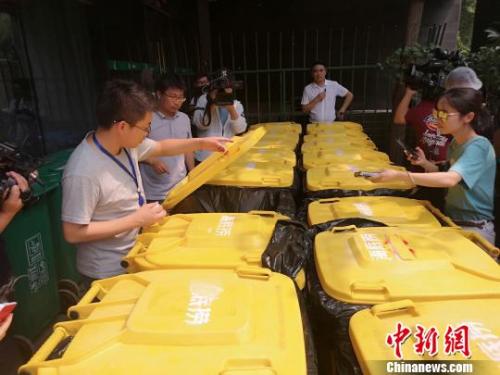 执法中队对垃圾桶进行现场检查。 张煜欢 摄