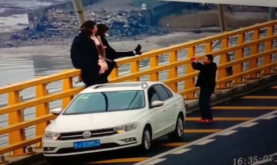 图为:4名女子高速上停车攀爬拍照。高速交警台州支队供图