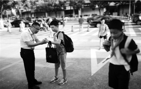 杨根法校长在校门口迎接学生。