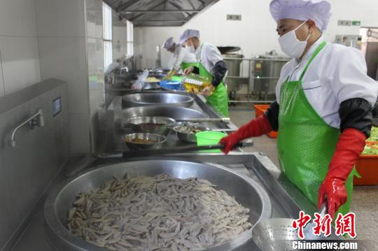 身着统一厨师服的戒毒人员正在准备饭菜 钱会广 摄