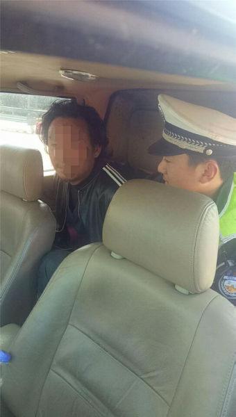 图为交警护送男子上警车离开 宁波高速交警供图