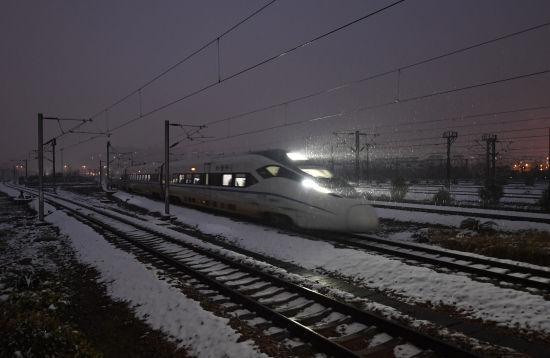 图为:一列高铁迎着大雪驶入浙江杭州火车东站。王刚摄