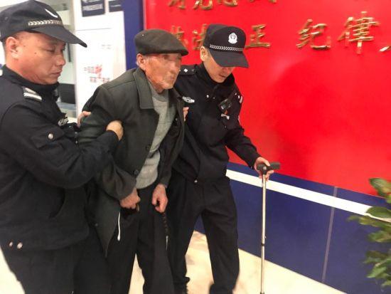 派出所里,值班的民警陆搀扶老人 彭梁平 摄