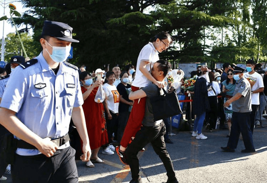 高考结束后，一位父亲激动地冲上前抱起女儿，就地转了一圈。