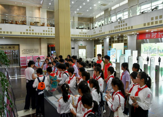 图为金沙湖实验小学生参观展览实物