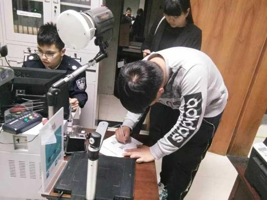 图为陈建忠在为小周办理业务