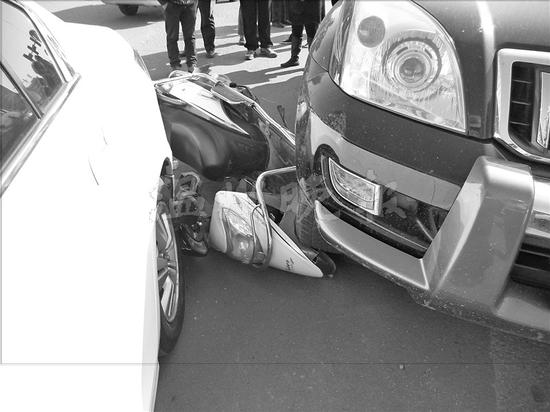 温州1电动车被两辆汽车夹心 骑车大妈戴头盔逃