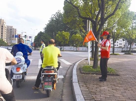 在马路上进行文明劝导的“红马甲”,图片来源:台州商报