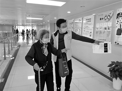 陆连国在李惠利东部医院帮助患者就医。