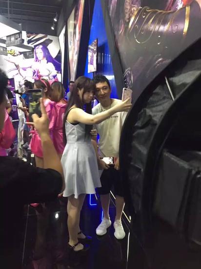 王思聪现身巨人《仙侠世界2》展台，并与一女子合影。