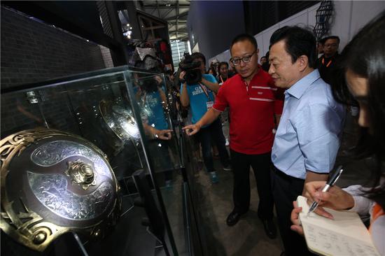 完美世界CEO萧泓博士向孙寿山理事长介绍中国战队在国际电竞比赛上获得的冠军奖品