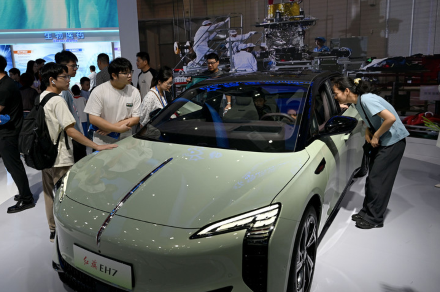 在2024世界制造业大会上,人们参观体验红旗EH7新能源汽车。新华社记者 黄博涵 摄
